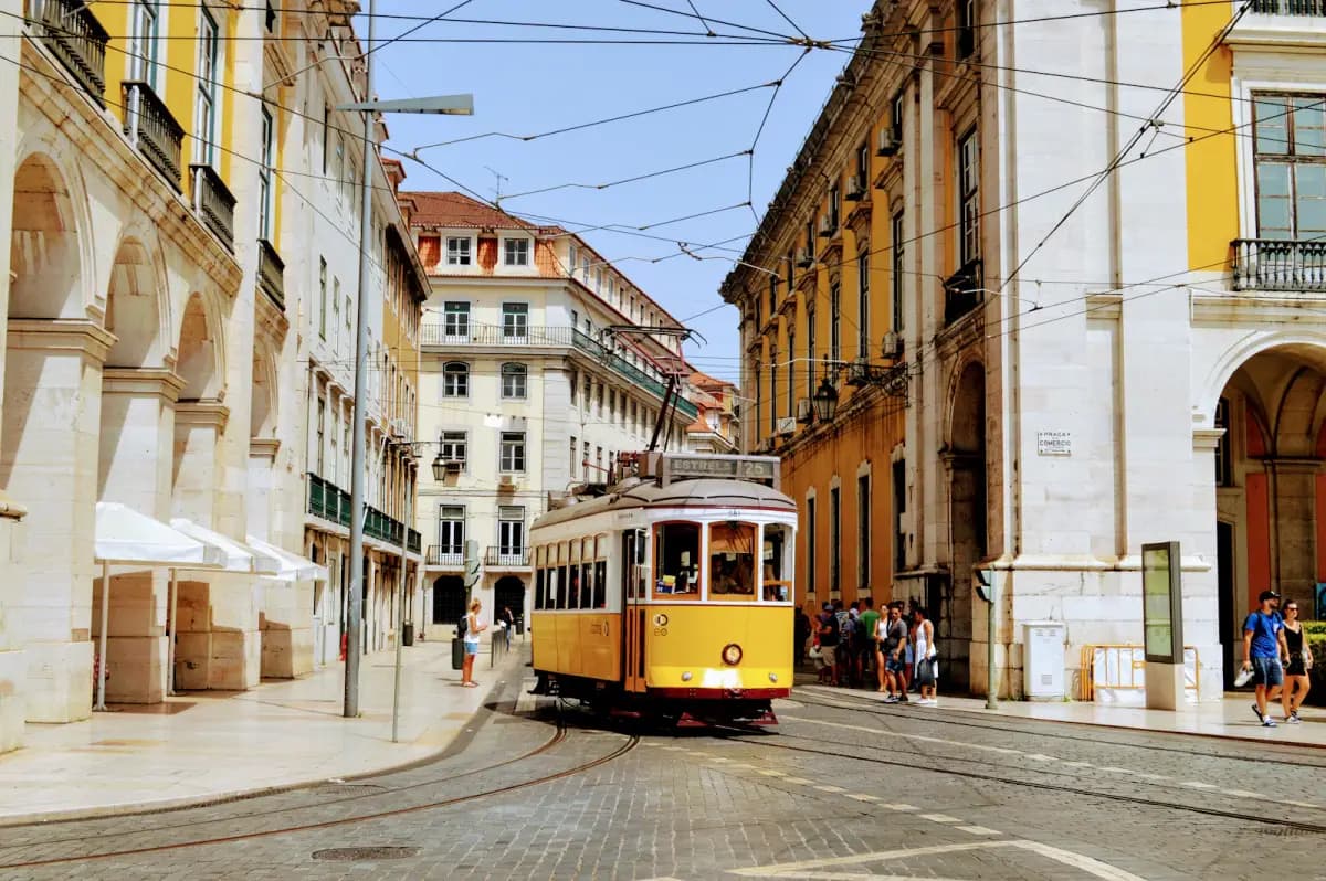 Yellow tram moving through a historic Lisbon street in Portugal