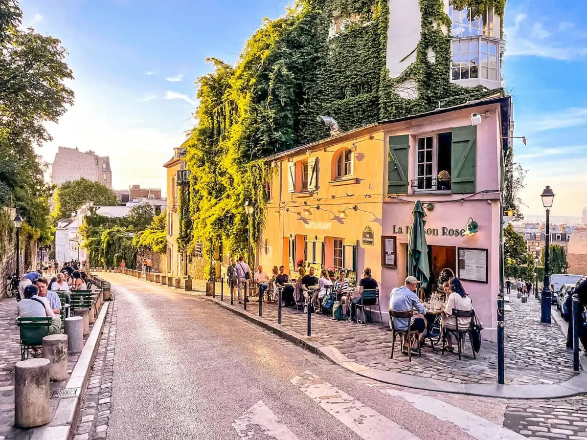 Sunlit cafe terrace on a cobblestone street in Montmartre, Paris
