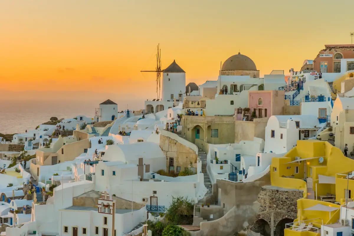 Whitewashed Santorini village and windmills above the Aegean Sea at sunset